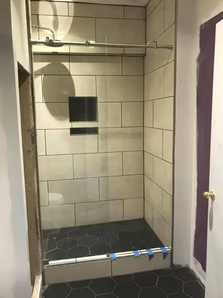 Tiled walk-in shower with a built-in niche and hexagon floor tile
