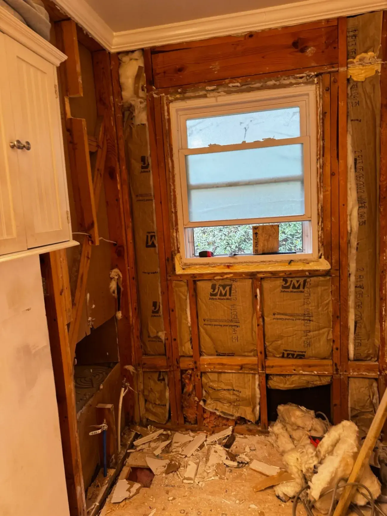Bathroom stripped to the framing and insulation before rebuilding