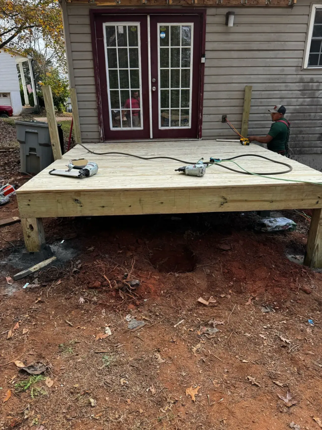 Crew member framing the deck boards on a new platform outside French doors