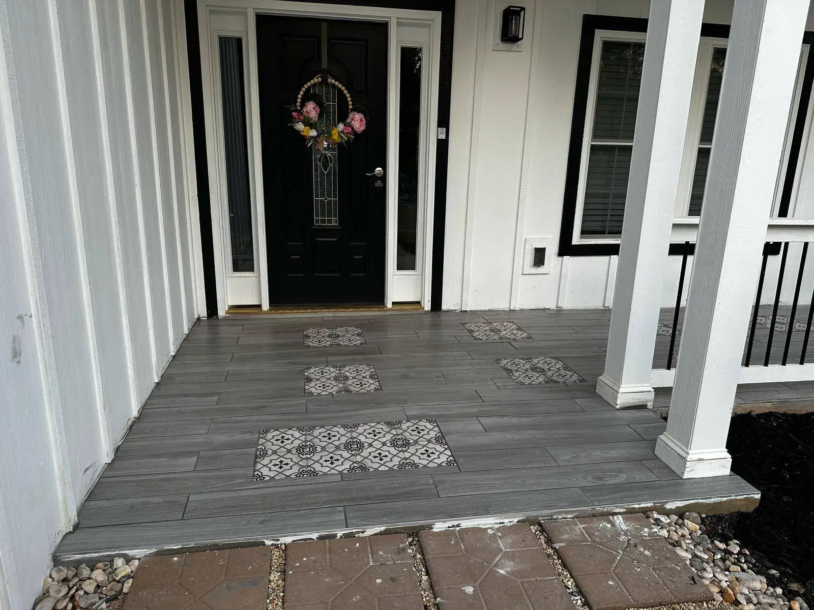 Covered entry with gray plank tile and patterned accents