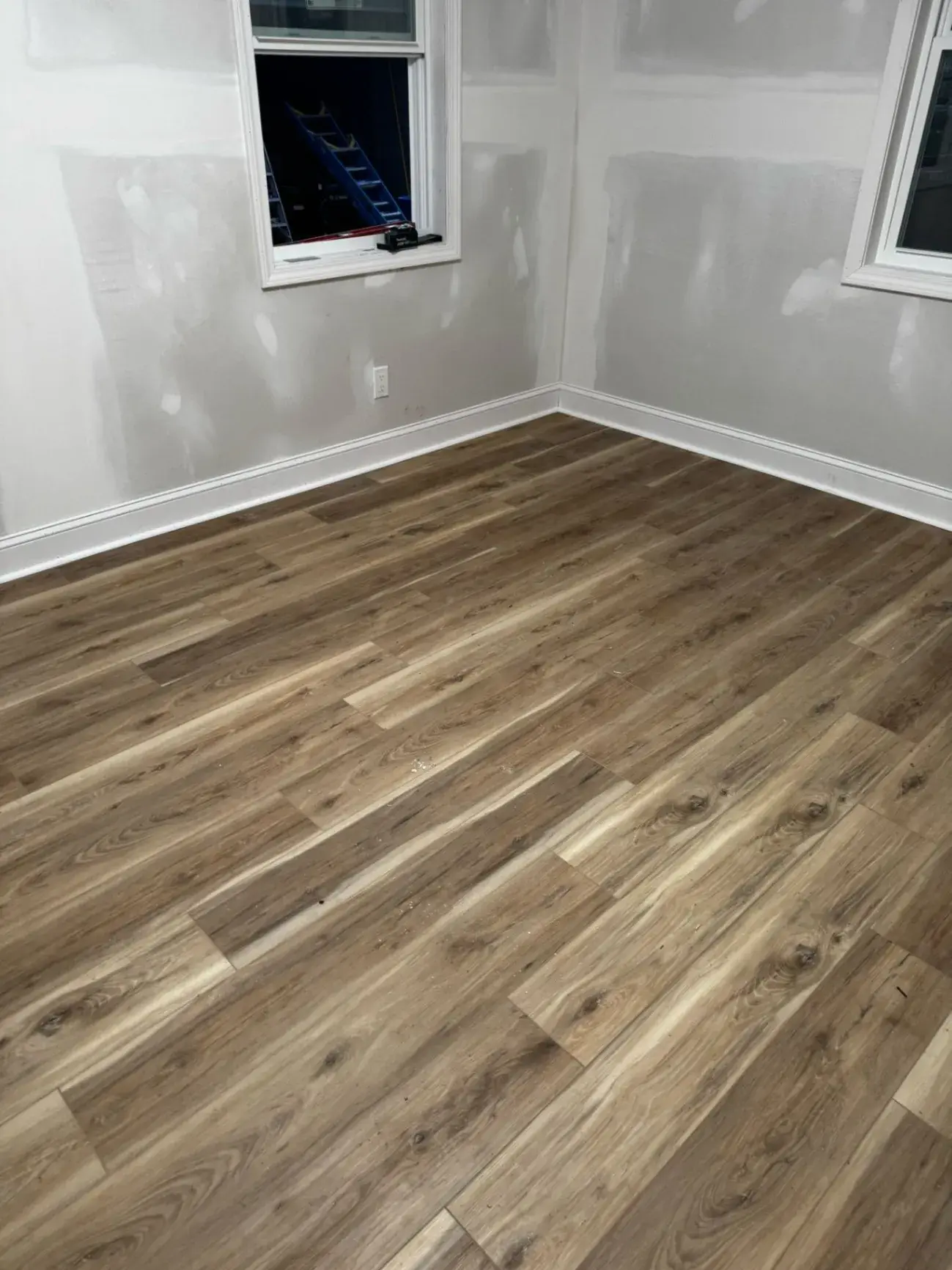 Newly installed wood-look floor in a primed room