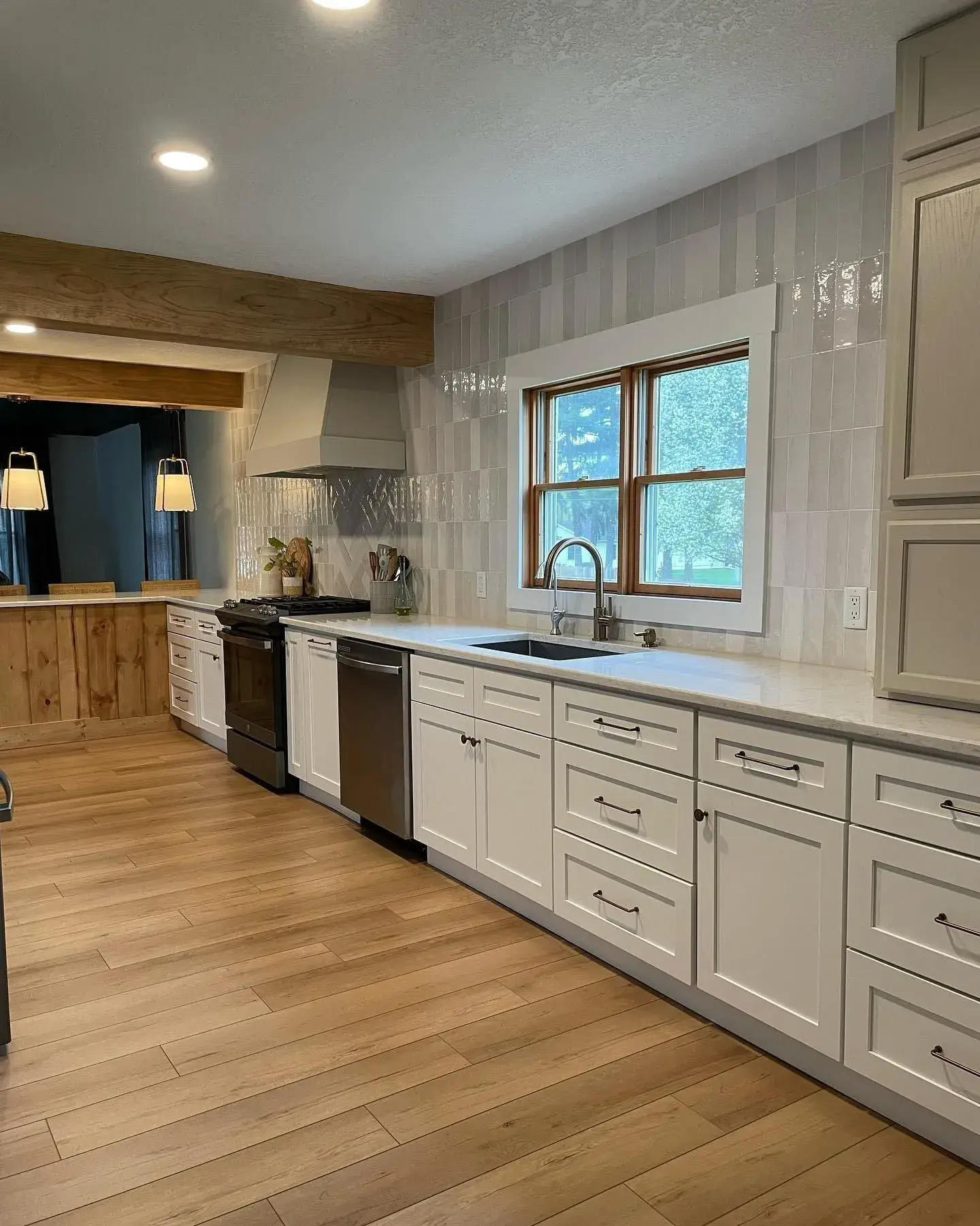Finished Kava kitchen with white cabinets and wood-look floor