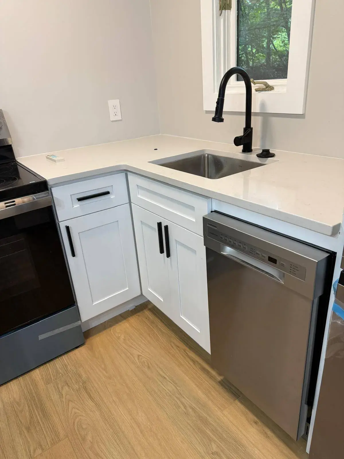 White corner cabinets with a quartz countertop and undermount sink