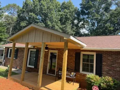 Covered front porch with wood posts on a brick home